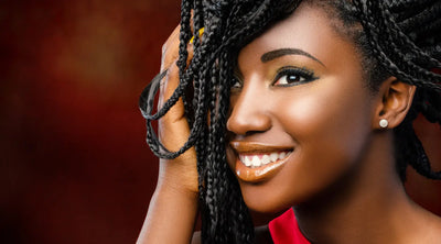 A close up portrait of a Black woman with beautiful braids and a perfect complexion