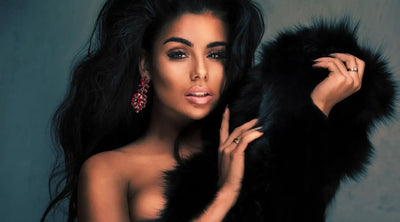 A beautiful Black woman with long jet black hair holding a fur coat