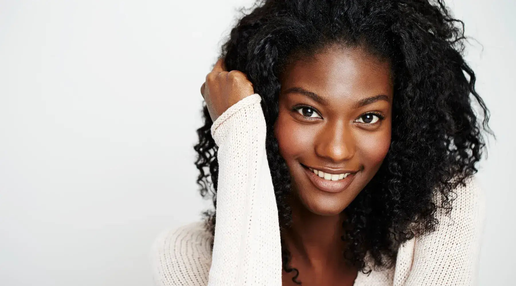 A black woman with shoulder-length black hair smiling for a candid portrait